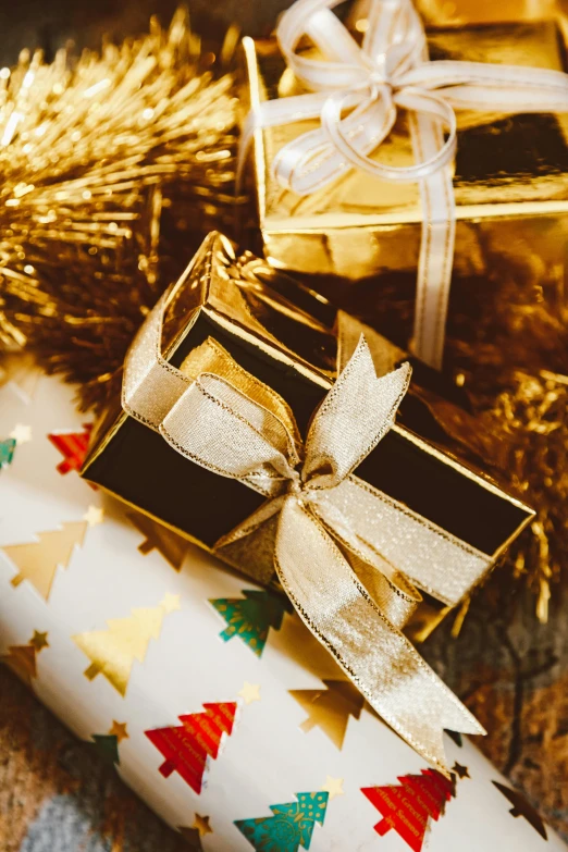 two wrapped presents sitting on top of a table, by Julia Pishtar, gold color scheme, holiday season, zoomed in, premium