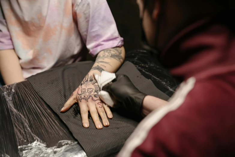 a man getting a tattoo on his hand, a tattoo, by Adam Marczyński, trending on pexels, hyperrealism, thumbnail, faded outline, 278122496, high-quality photo