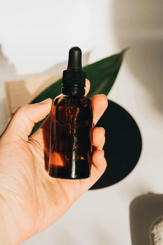 a person holding a bottle of essential oil, by Julia Pishtar, trending on pexels, made of smooth black goo, maple syrup highlights, nootropic stimulant, rectangle