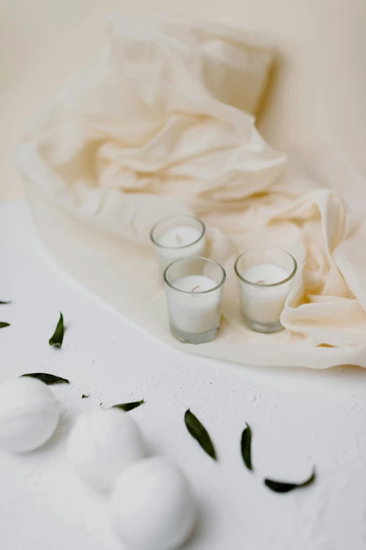 a bunch of candles sitting on top of a table, white cloth, detailed product image, soft lens, detail shot