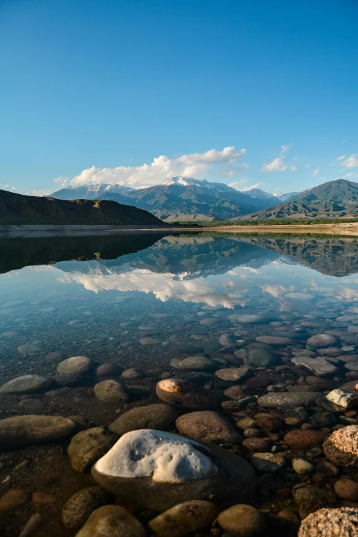 a body of water surrounded by rocks and mountains, idaho, reflect, intense gaze, 4k photo”