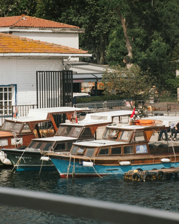 a number of boats in a body of water near a building, on a boat, istanbul, sitting on a wood dock