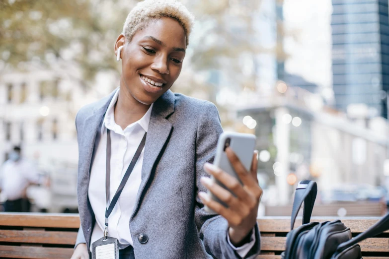 a woman sitting on a bench using a cell phone, trending on pexels, wearing a business suit, african female android, a blond, thumbnail