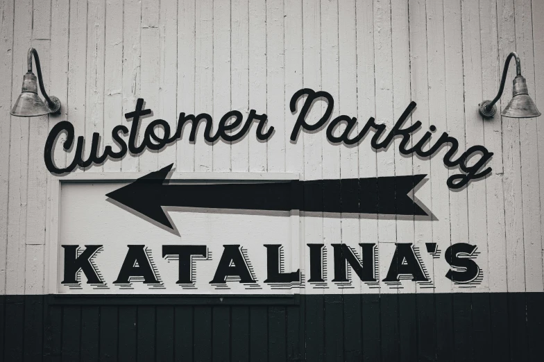a black and white photo of a customer parking sign, by Jaakko Mattila, trending on unsplash, the entrance of valhalla, vintage colors, latinas, actual photo