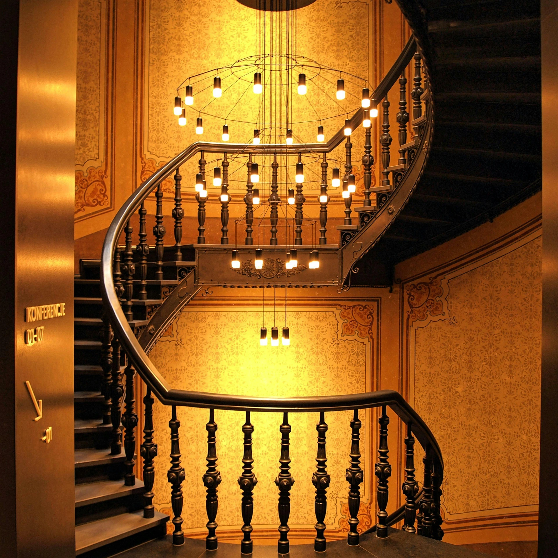 a spiral staircase in a building with a clock on the wall, by Lubin Baugin, art nouveau, yellow artificial lighting, dramatic lighting - n 9, chandelier, trending artwork