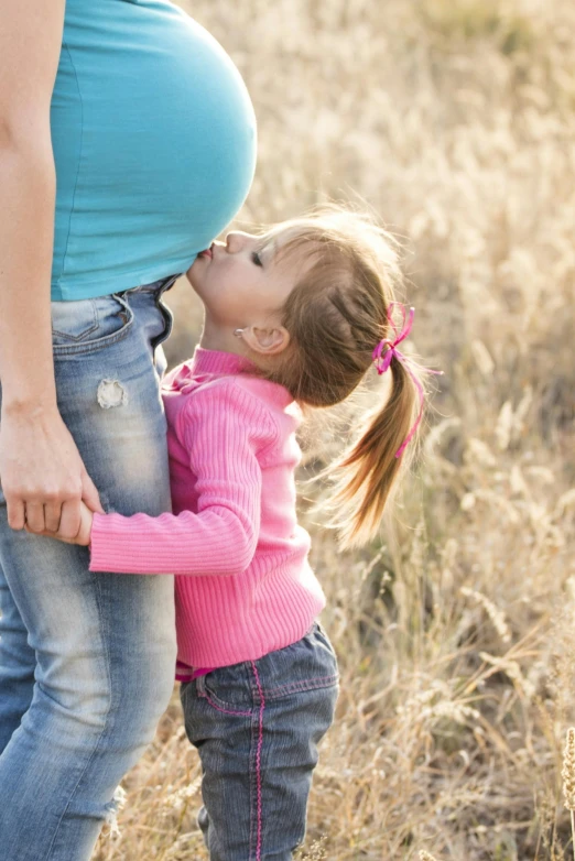 a pregnant woman kissing a little girl in a field, pexels, belly button showing, blank, multi-part, denim