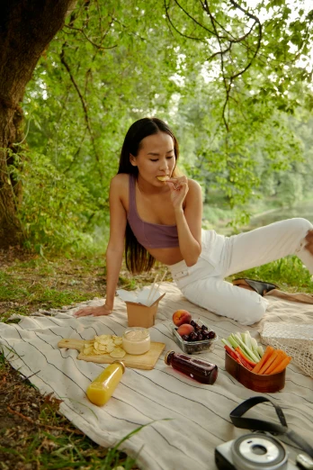 a woman sitting on top of a blanket next to a picnic basket, trending on pexels, renaissance, lara croft eating durian, eating garlic bread, wearing a crop top, fine dining