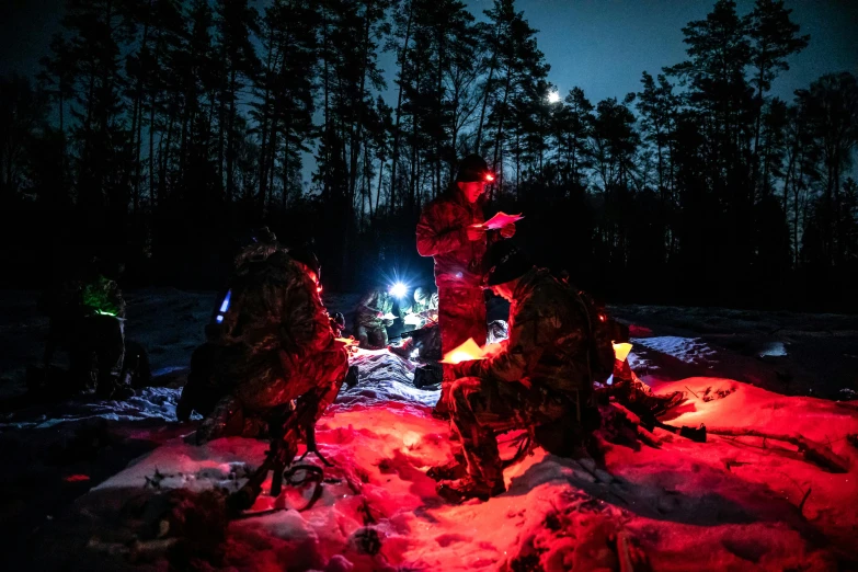 a group of people sitting around a fire in the snow, by Adam Marczyński, hurufiyya, night vision goggles, male soldier in the forest, blue and red lighting, ready to eat