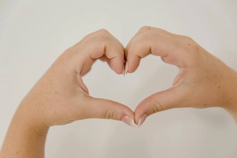 a person making a heart with their hands, pexels, fan favorite, male and female, profile image, dimples