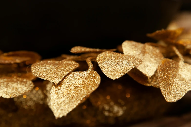a close up of a bunch of gold leaves, by Julia Pishtar, hurufiyya, fairy lights, product display photograph, hearts, thumbnail
