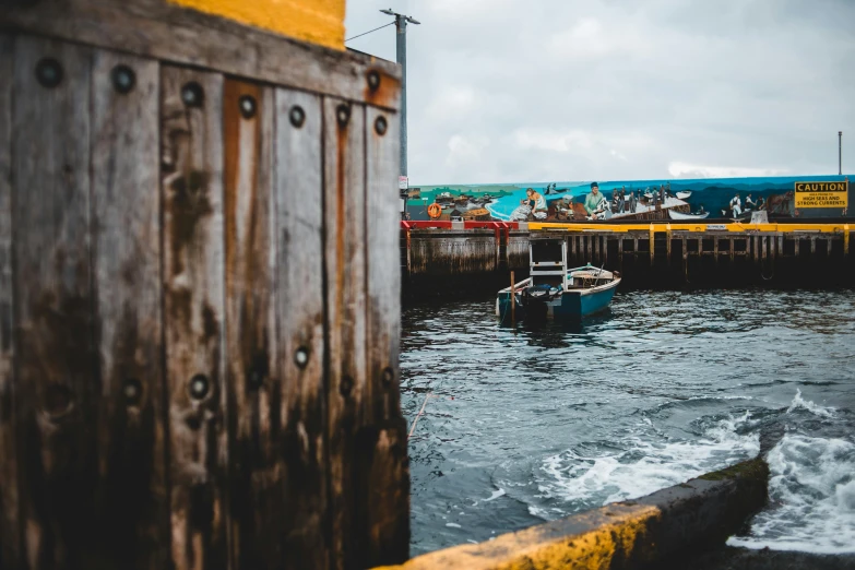 a boat that is sitting in the water, by Carey Morris, pexels contest winner, port scene background, vibrant but dreary, yellow and blue, 🦩🪐🐞👩🏻🦳