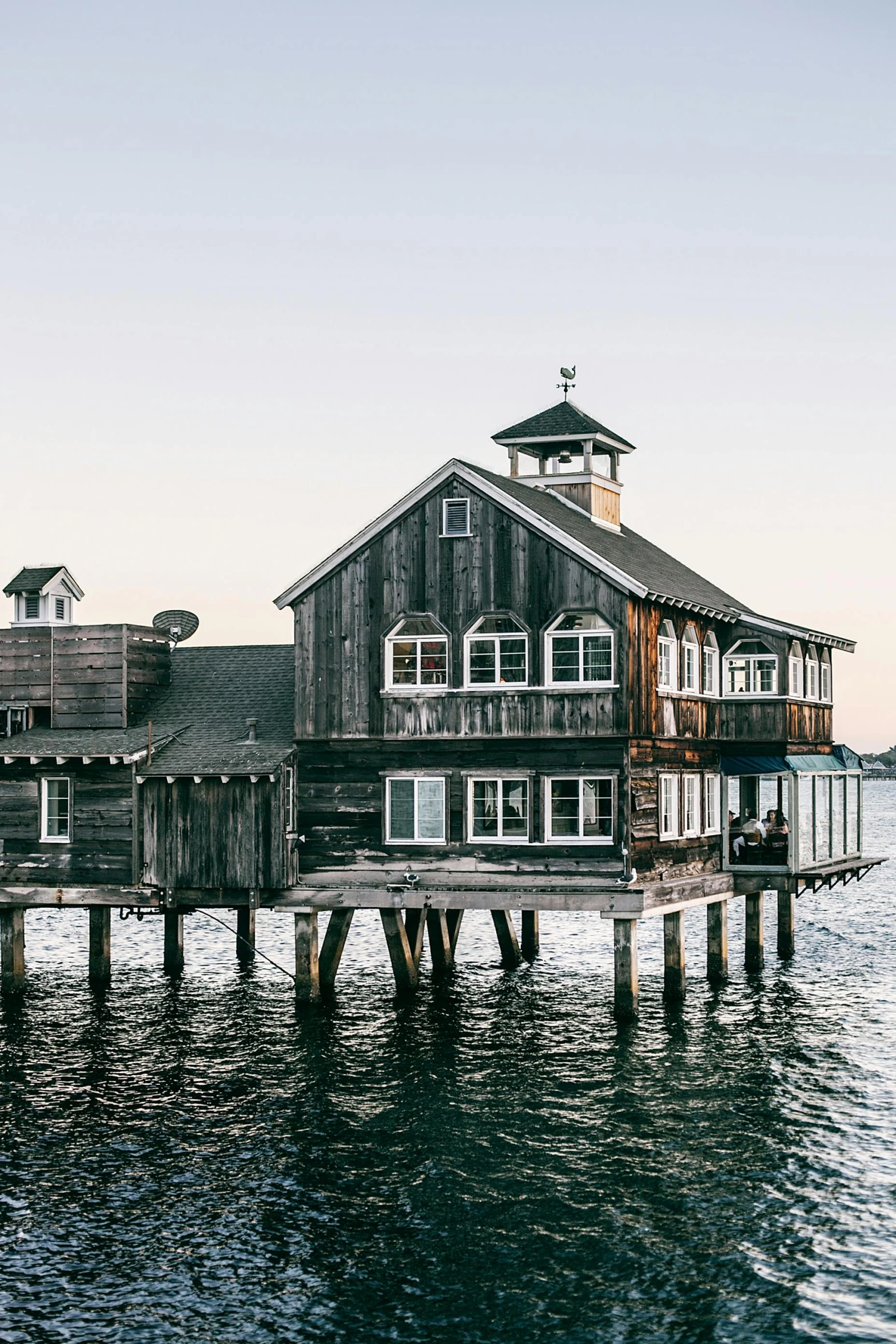 a wooden building sitting on top of a body of water, pexels contest winner, peter hurley, rhode island, built around ocean, architectural digest