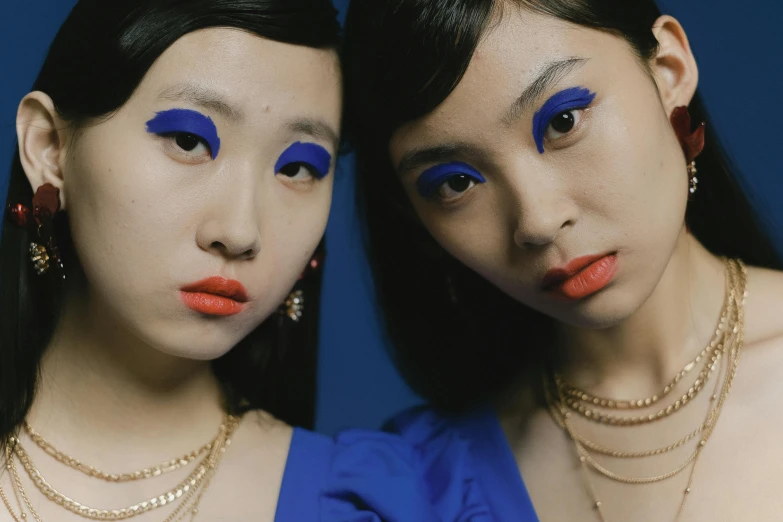 a couple of women standing next to each other, an album cover, inspired by Wang Duo, trending on pexels, blue lipstick, multiple eyes, chinese, youtube thumbnail