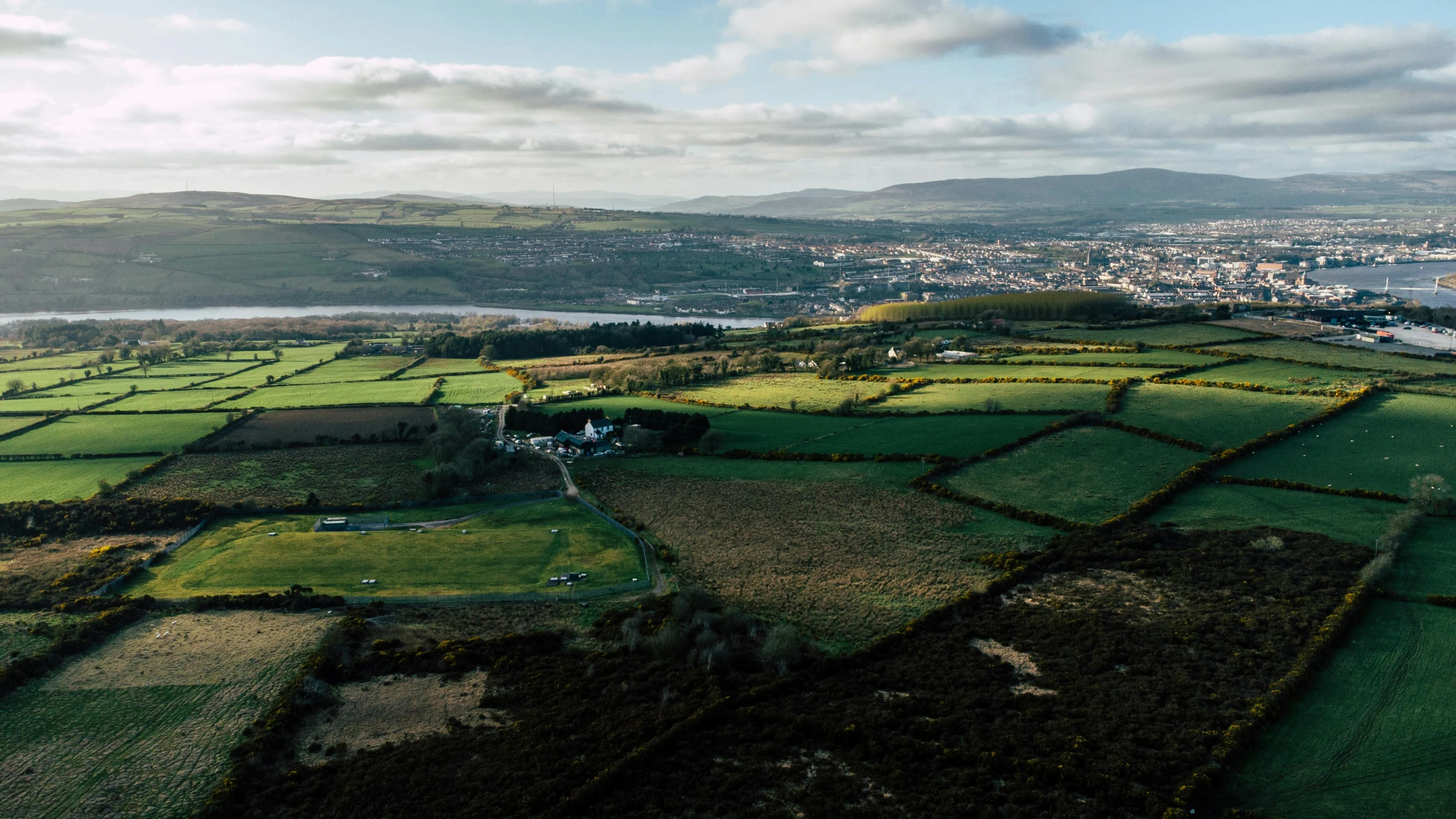 a view of the countryside from a bird's eye view, a picture, by Lee Loughridge, pexels contest winner, happening, holywood scene, panorama of crooked ancient city, analogue, hills in the background