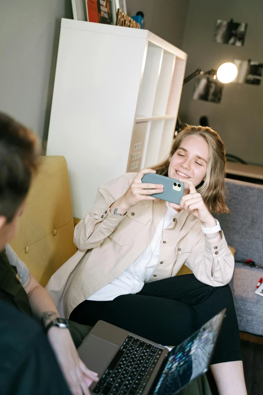 a woman sitting on a couch taking a picture of herself, a picture, trending on pexels, smiling couple, julia hetta, sat in an office, low quality photo