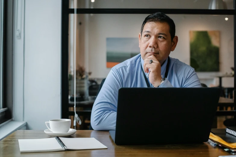 a man sitting in front of a laptop computer, unsplash, temuera morrison, hoang long ly, thoughtful ), mid - 3 0 s
