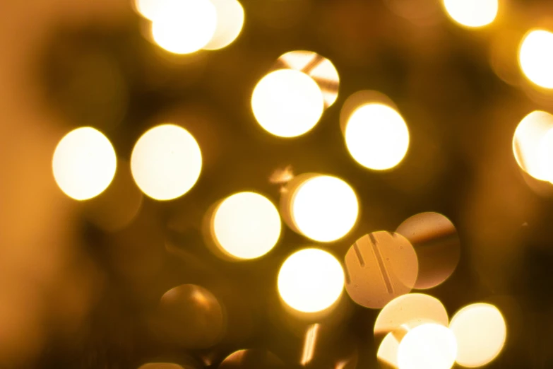 a close up of a christmas tree with lights, unsplash, minimalism, golden dappled dynamic lighting, light circles, gold colours, scattered light