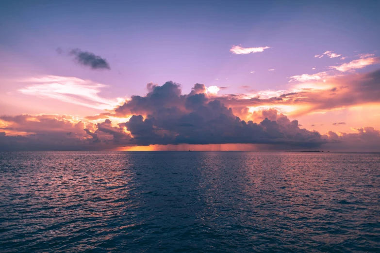 a sunset over the ocean with clouds in the sky, pexels contest winner, great barrier reef, purple omnious sky, instagram post, humid evening