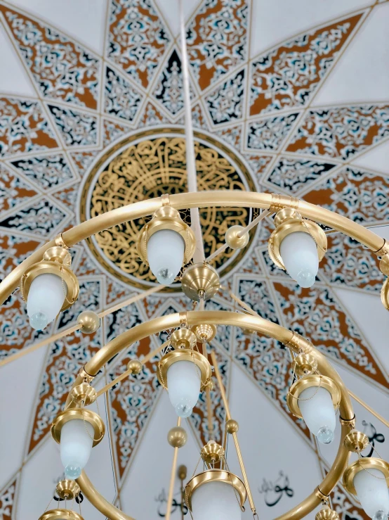 a chandelier hanging from the ceiling of a building, a detailed painting, inspired by Osman Hamdi Bey, trending on unsplash, arabesque, white and gold color scheme, electrical details, closeup - view, sconces