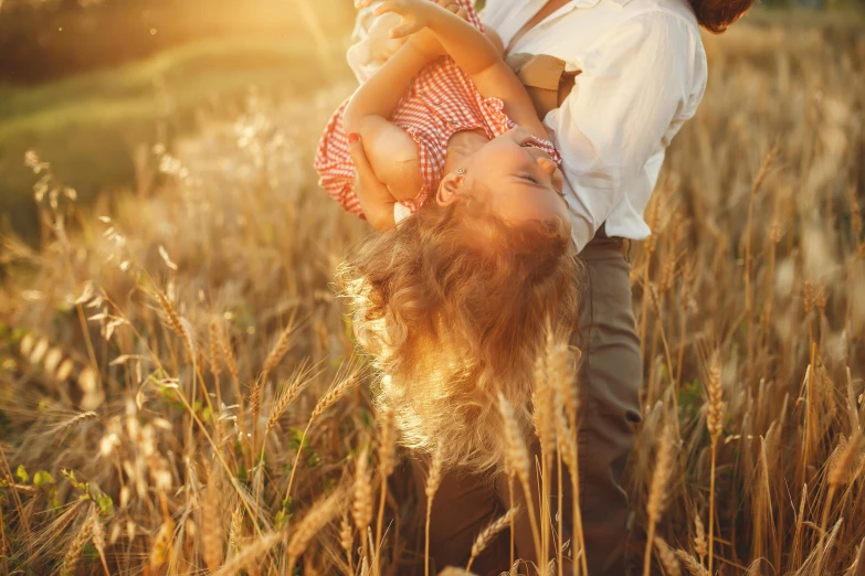 a man holding a little girl in a field, pexels contest winner, symbolism, flying hair, sunny lighting, retro stylised, harvest