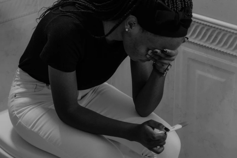 a black and white photo of a woman sitting on a toilet, a black and white photo, pexels, woman crying, african woman, holding syringe, beautiful crying! android woman