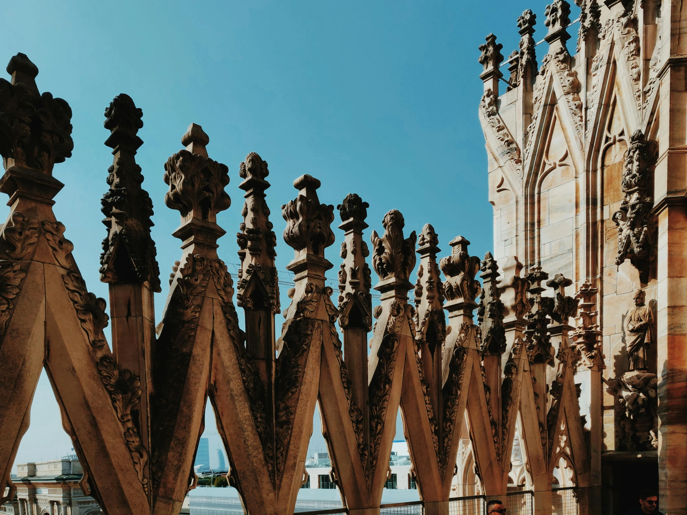 a couple of people that are standing in front of a building, an album cover, by Cagnaccio di San Pietro, pexels contest winner, baroque, detailed fences and stone walls, asymmetrical spires, view from bottom to top, made of intricate metal and wood