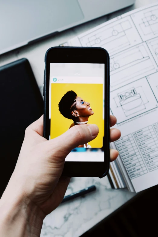 a close up of a person holding a cell phone, a picture, happening, on a yellow paper, at behance, instagram digital, portrait size