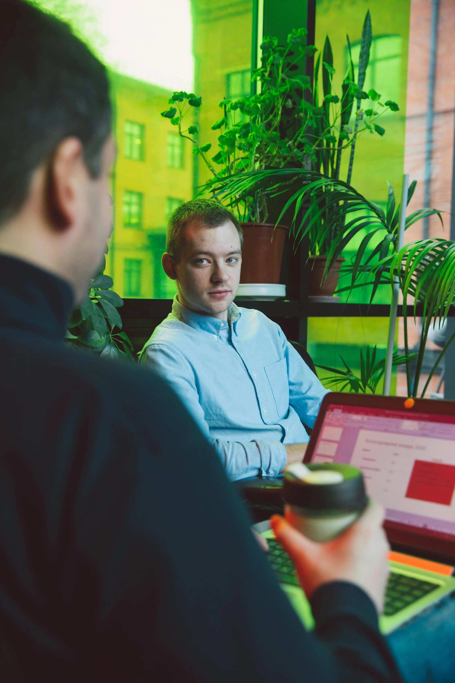 a group of people sitting around a table with laptops, a screenshot, by Sven Erixson, unsplash, medium shot of two characters, tarmo juhola, programmer, in the office