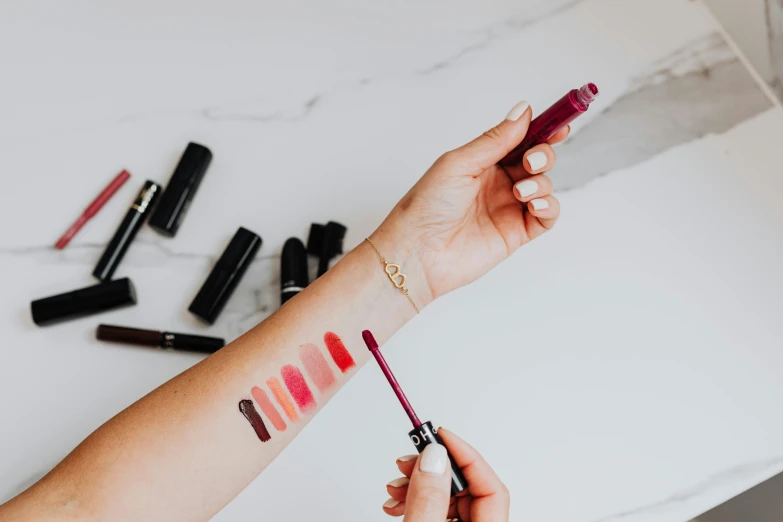 a close up of a person holding a lipstick brush, by Nicolette Macnamara, trending on pexels, flatlay, gradient red to black, muted arm colors, lined up horizontally