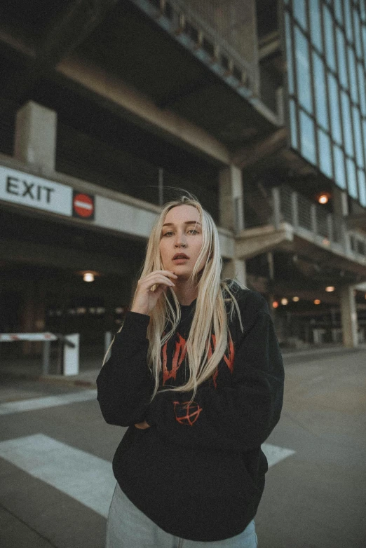 a woman standing on a city street talking on a cell phone, an album cover, inspired by Elsa Bleda, pexels contest winner, realism, wearing a black hoodie, perfect white haired girl, portrait of kim petras, at a mall