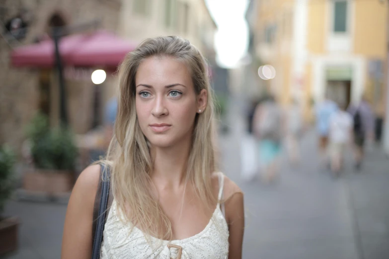 a beautiful young woman standing in the middle of a street, pexels contest winner, renaissance, blond hair green eyes, medium format. soft light, italian, annoyed