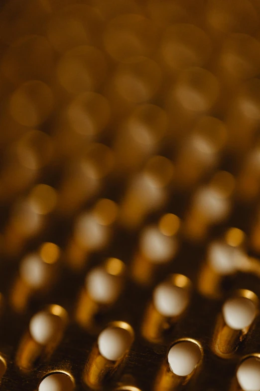 a bunch of bullet shells sitting on top of a table, a macro photograph, inspired by Andreas Gursky, unsplash, digital art, honey ripples, soft light - n 9, grain”