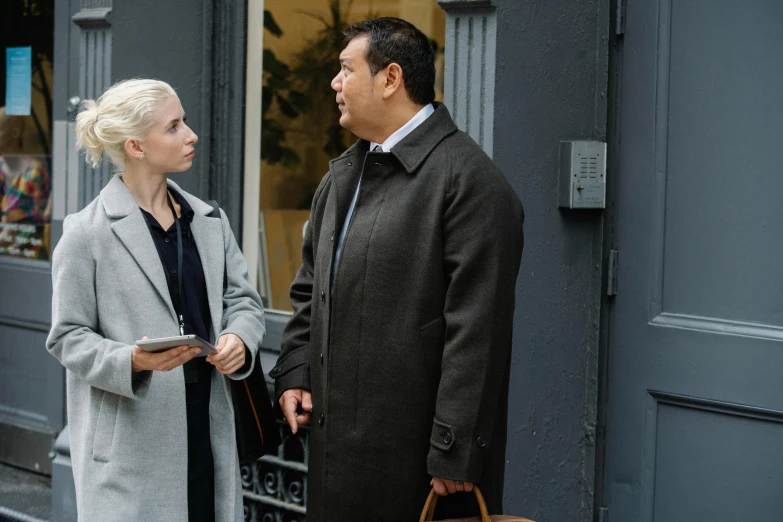 a man and a woman standing outside of a building, detective coat, damien tran, a blond, in new york city