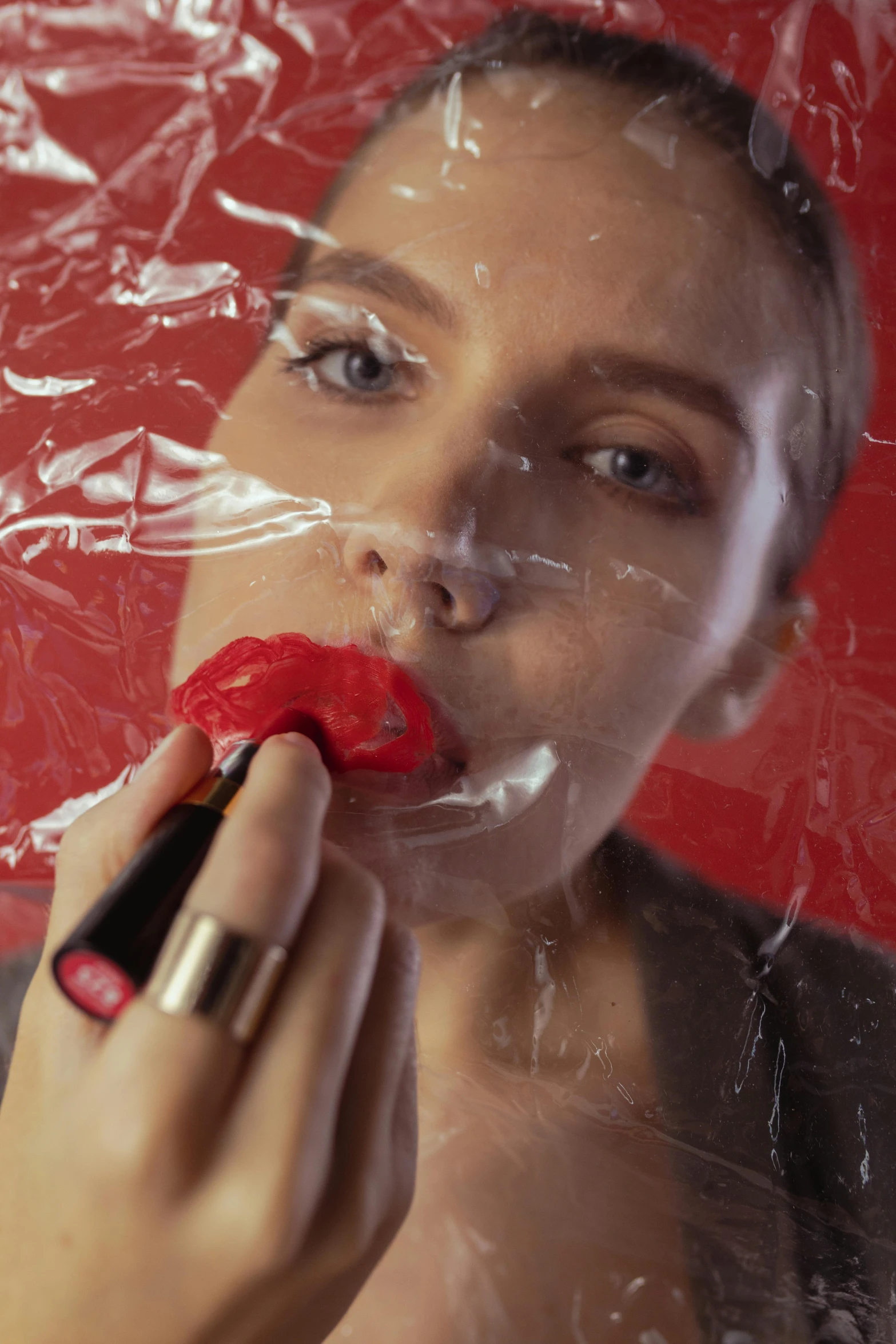 a woman is putting lipstick on her lips, a hyperrealistic painting, inspired by Bert Stern, trending on pexels, plastic wrap, film still promotional image, maxim sukharev, red colored