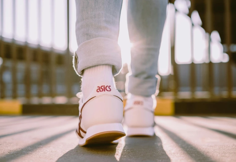 a close up of a person walking on a sidewalk, trending on pexels, maroon and white, asthetics, wearing white clothes, sneaker design