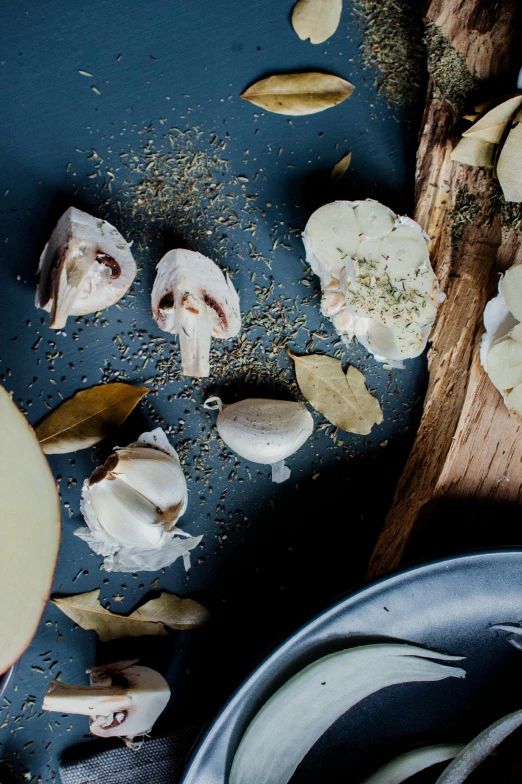 a wooden cutting board topped with sliced apples, a still life, trending on unsplash, renaissance, garlic on background, thumbnail, dried herbs, blue