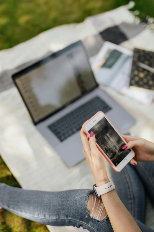 a woman sitting on a blanket using a cell phone, a picture, trending on unsplash, happening, using a macbook, professional digital edit, scanning items with smartphone, sitting in the garden