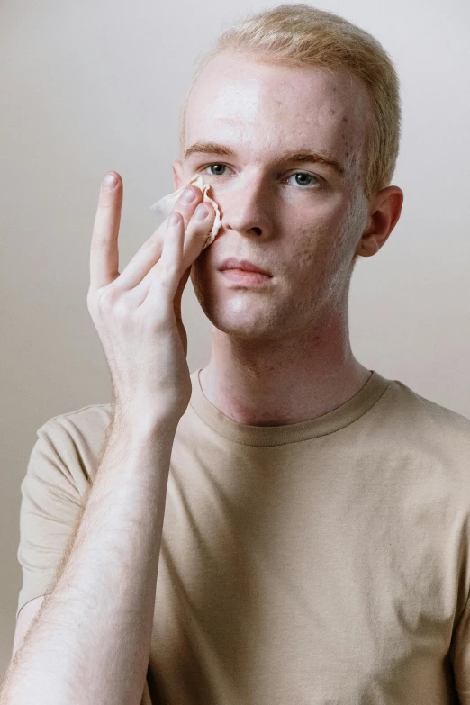 a man holding a cell phone up to his face, an album cover, pexels, hyperrealism, freckled pale skin, white bandages on fists, non binary model, wrinkles and muscle tissues