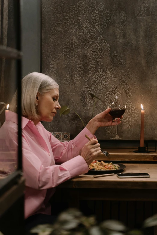 a woman sitting at a table with a glass of wine, inspired by Elsa Bleda, pexels contest winner, renaissance, gray haired, smoking a bowl of hash together, candle lighting, gif