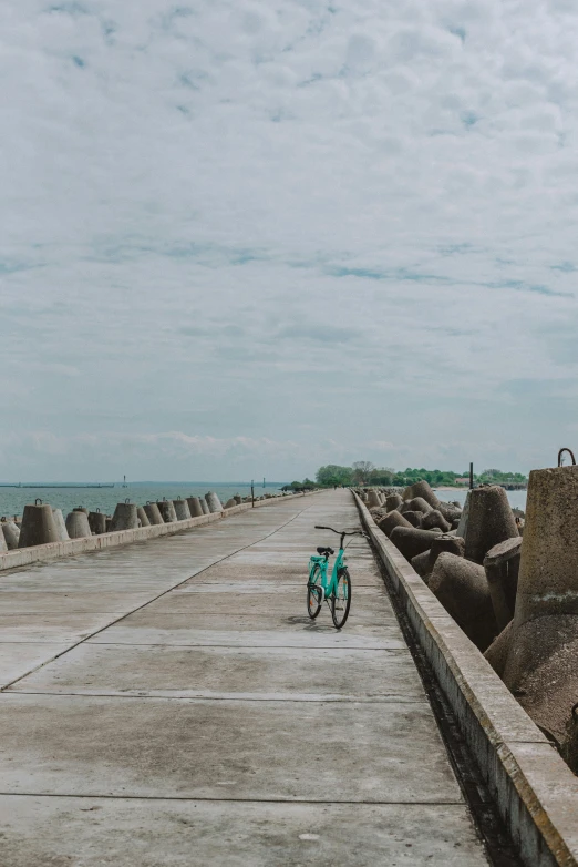 a bicycle parked on a pier next to the ocean, by Yi Insang, unsplash, panoramic shot, concrete pillars, low quality photo, walking