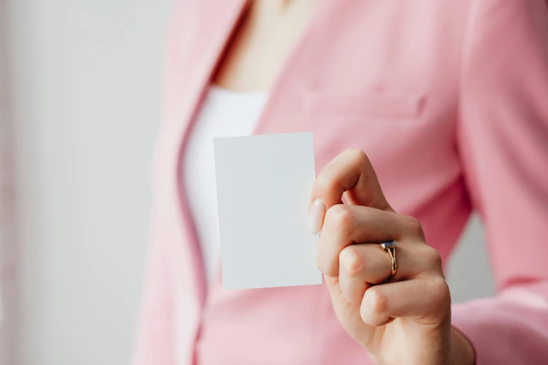 a woman in a pink jacket holding a white card, unsplash, highly polished, wearing white cloths, profile image, multiple stories