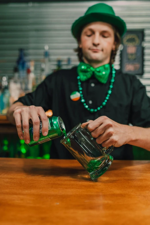 a man in a green hat pouring a drink, green suit and bowtie, clover, hands on counter, 2019 trending photo