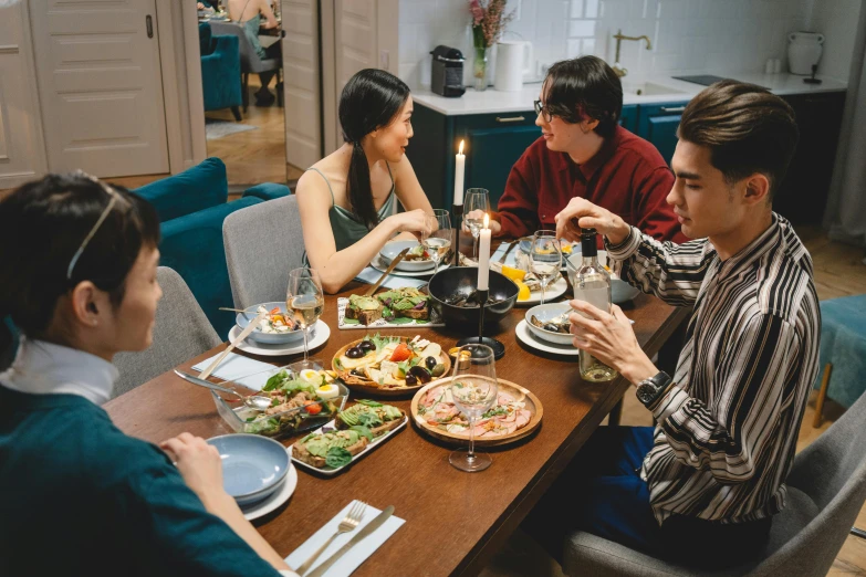 a group of people sitting around a wooden table, dinner table, profile image, bowl filled with food, on a table