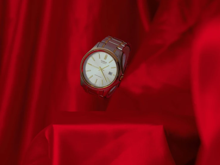 a close up of a watch on a red cloth, by Elsa Bleda, pexels contest winner, magic realism, shades of aerochrome gold, stainless steal, random background scene, hua cheng