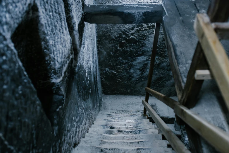 a set of stairs going up the side of a building, inspired by Elsa Bleda, pexels contest winner, in an icy cavern, movie still from game of thrones, dirty old grey stone, dark concrete room