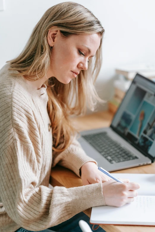 a woman sitting at a desk in front of a laptop, pexels contest winner, academic art, holding pencil, profile image, official screenshot, multiple stories