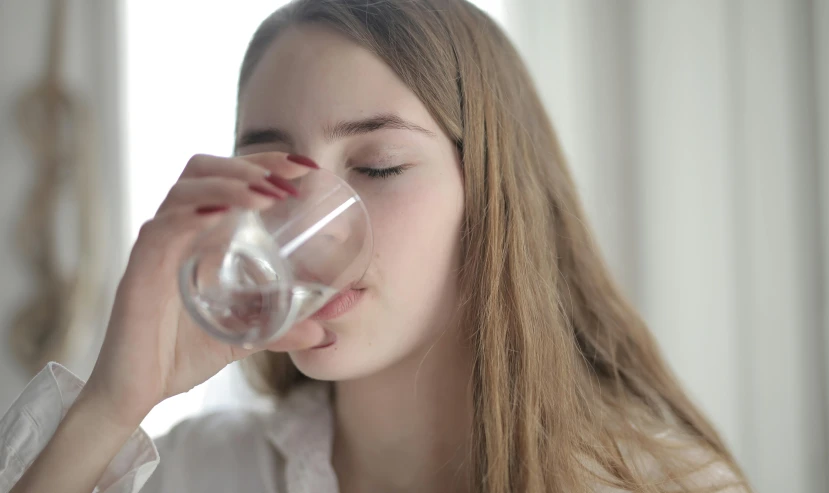 a woman is drinking a glass of water, by Carey Morris, pexels, renaissance, teenager, avatar image, medical, close - up photo