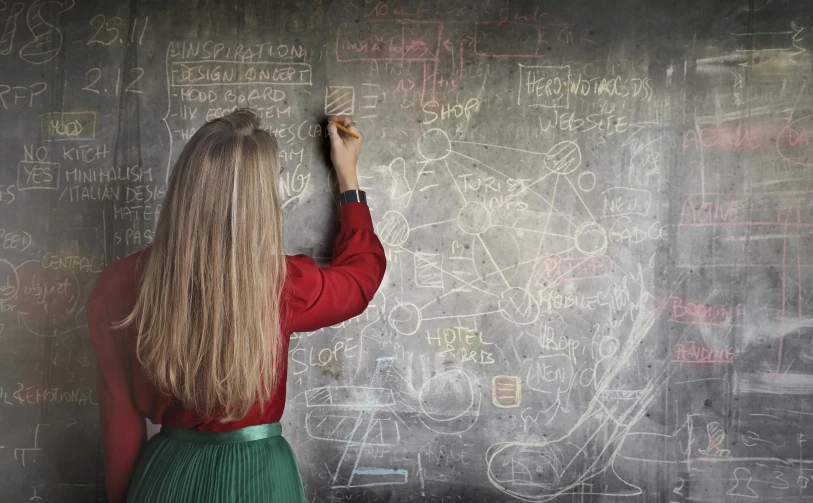 a woman writing on a blackboard with chalk, trending on pexels, background image, technical, curiosity, high class