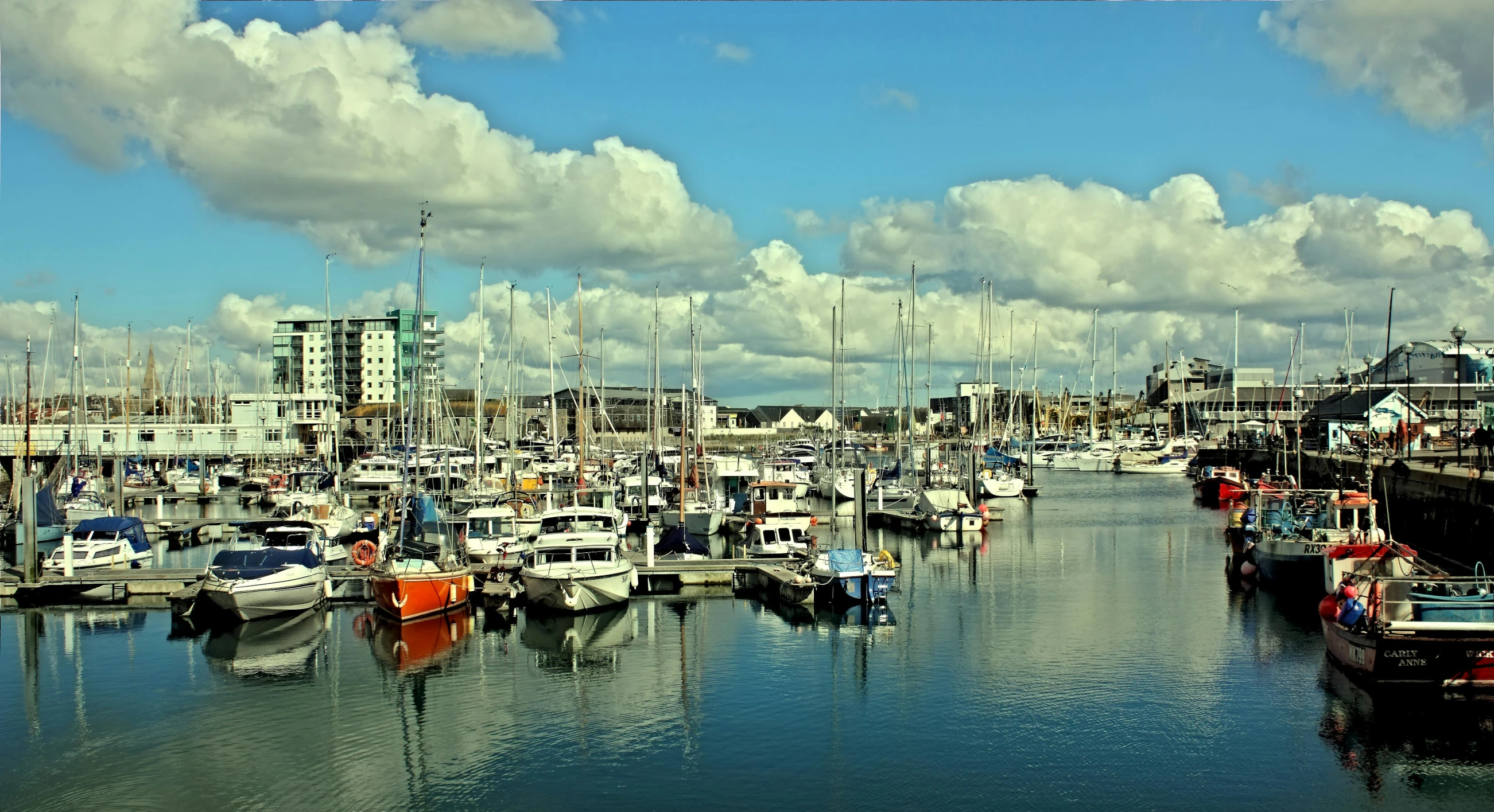 a harbor filled with lots of boats under a cloudy blue sky, by Lee Loughridge, flickr, hull, mayo, portrait photo, vivid and vibrant