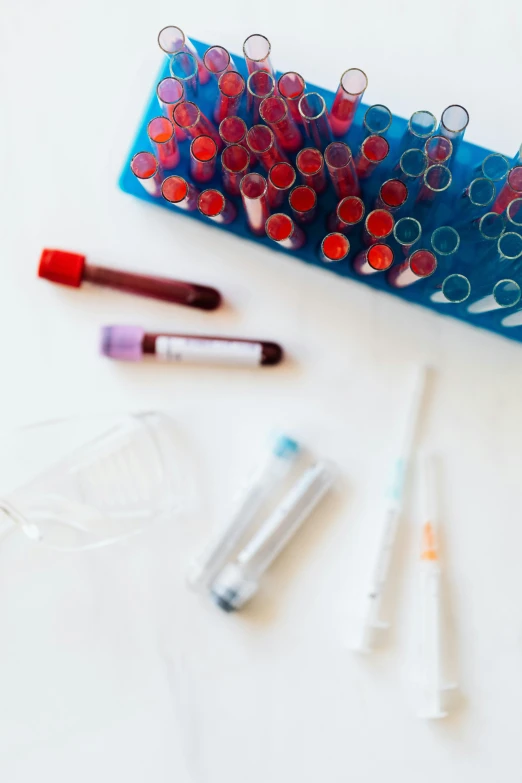 a bunch of tubes sitting on top of a table, a picture, unsplash, blood smear, nursing, pharmacy, maroon and blue accents